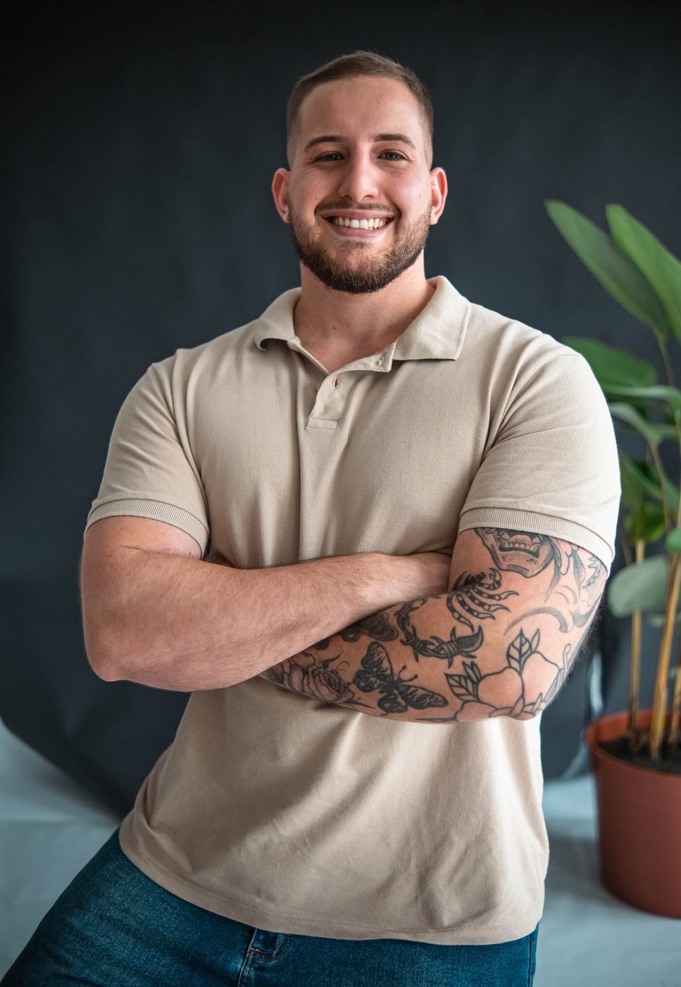 Igor Kist, massoterapeuta em Balneário Camboriú, sorrindo de braços cruzados